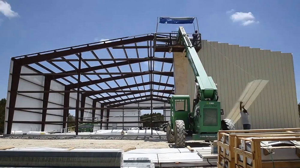 The factory has a high steel frame and roof
